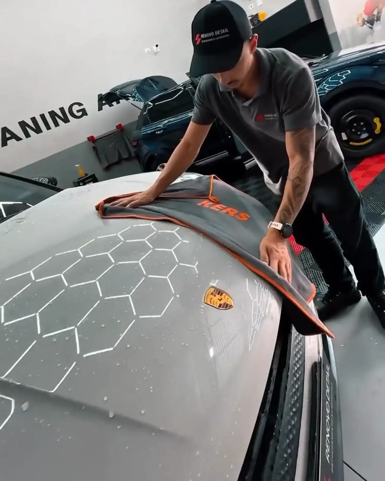 Profissional da Renovo secando a carroceria de um Porsche